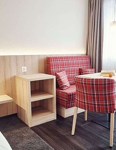 Modernes Zimmer mit roten karierten Möbeln und Tisch.