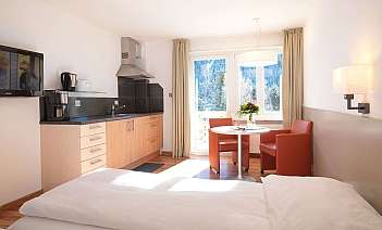 Gemütliches Hotelzimmer mit Küchenzeile und Essbereich.