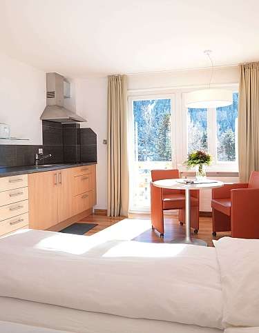 Gemütliches Hotelzimmer mit Küchenzeile und Essbereich.
