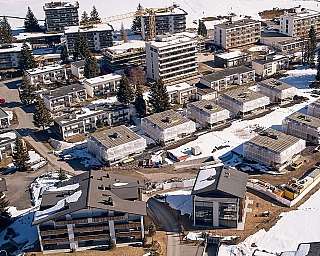 Luftaufnahme eines Wohngebiets mit Schnee und Bauarbeiten.