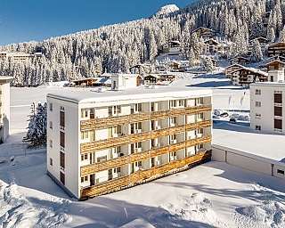 Schneebedeckte Gebäude in einer winterlichen Berglandschaft.